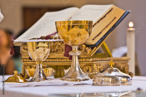 pisside and chalice contain wine and hosts on the altar of the mass photo