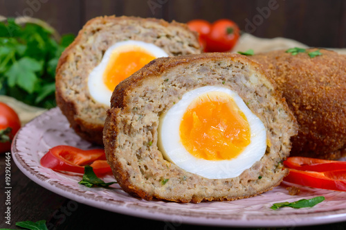 Large juicy cutlets stuffed with boiled egg on a dark wooden background. Scottish cutlet.