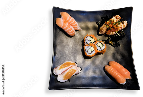 close up of chopsticks taking portion of sushi roll on the table restaurant / eating sushi roll using chopsticks