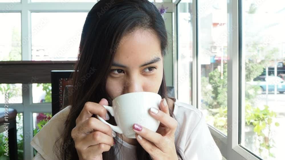 Pretty asian woman drinking coffee and relaxing in cafe Pretty asian woman drinking coffee and relaxing in cafe