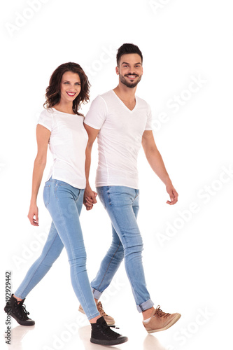 young happy casual couple is walking and holding hands