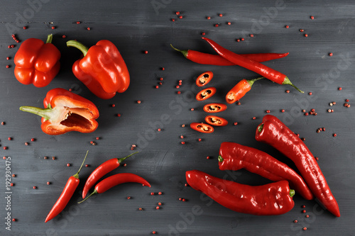 A set of a variety of red pepper. In the frame, pepper is cayenne, sweet and Ramiro sort. Dark wooden background. Close-up. View from above.