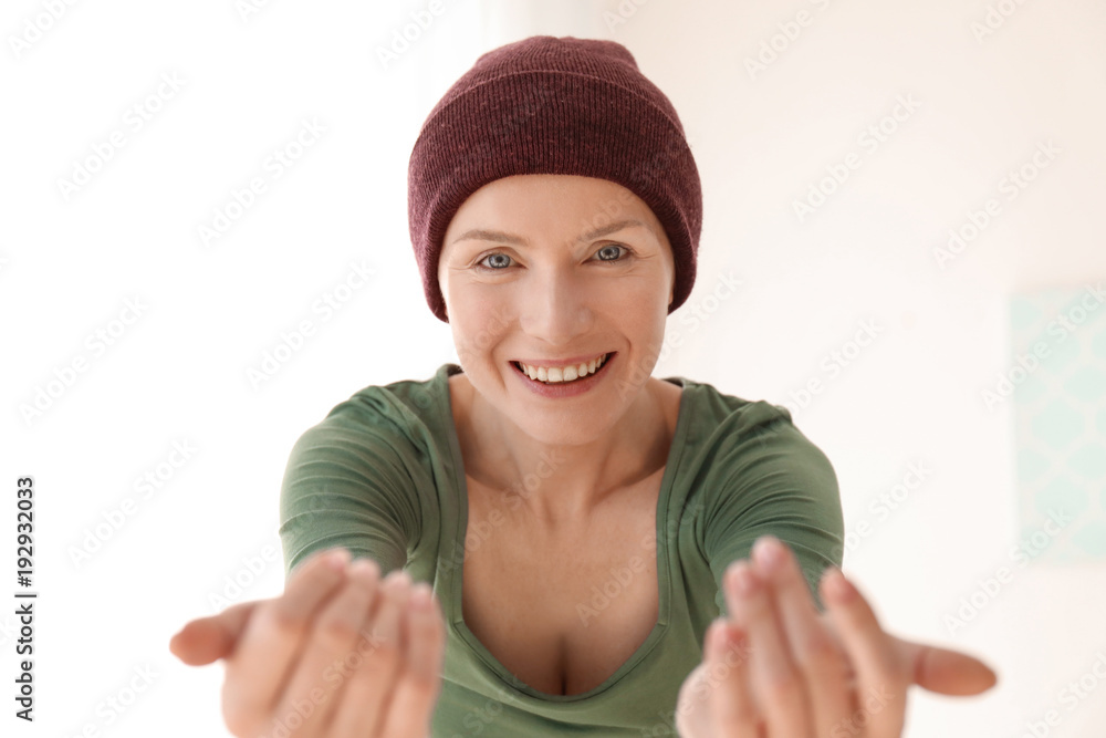 Young woman with cancer in hat on light background Young woman with cancer in hat on light background