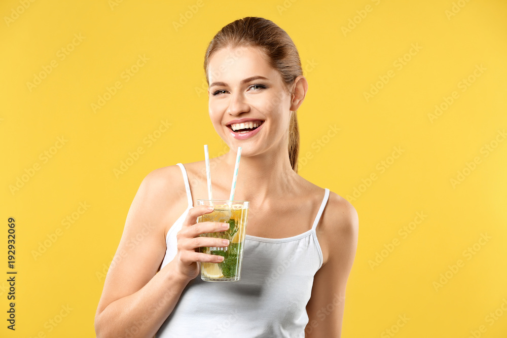 Beautiful young woman with glass of lemonade on color background Beautiful young woman with glass of lemonade on color background