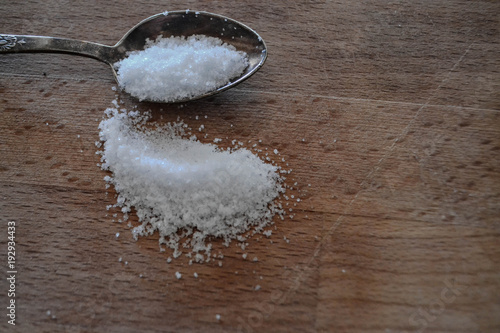 Sea salt crystals whit spoon at rustic wooden background 