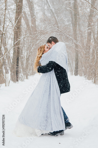 Couple on nature in winter during a snowfall