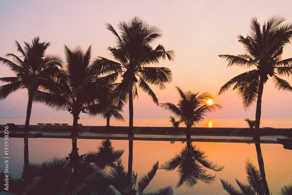 Silhouette coconut palm tree around outdoor swimming pool
