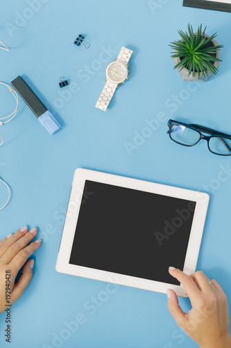 Female hand clicks on screen of tablet, top view