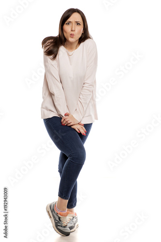 young woman need a toilet on white background