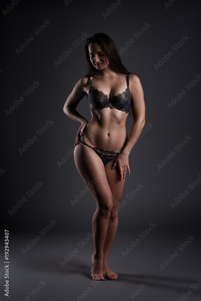 Beautiful sexy woman in lingerie posing on gray studio background, perfect female body
