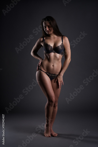 Beautiful sexy woman in lingerie posing on gray studio background, perfect female body