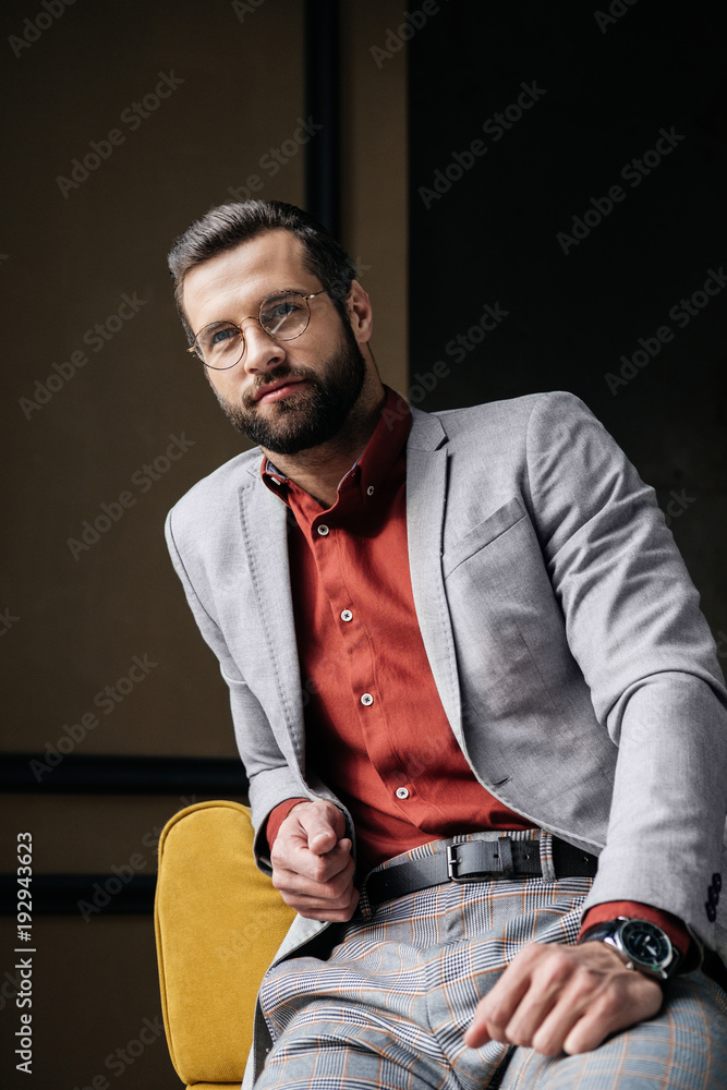 handsome stylish elegant man in glasses and suit sitting on couch handsome stylish elegant man in glasses and suit sitting on couch