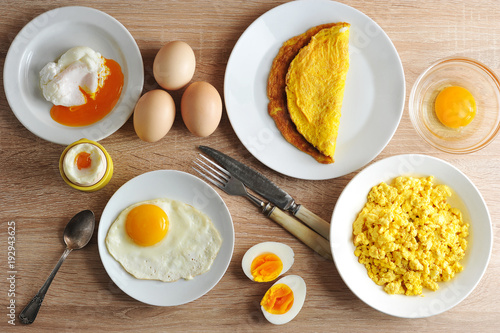 Various ways of cooking chicken eggs. Omelette, poached, soft-boiled, hard-boiled, fried, scrambled eggs.  Top view. Close-up.