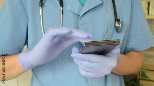 male doctor working on phone with gloves and dress code photo