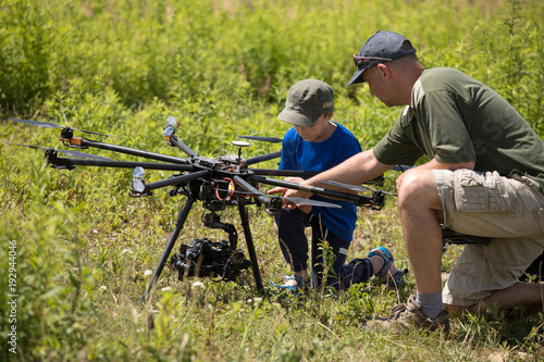 learning to fly a drone, father trains son piloting drone