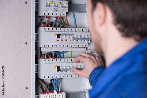 Elektriker arbeitet an einem Sicherungskasten 