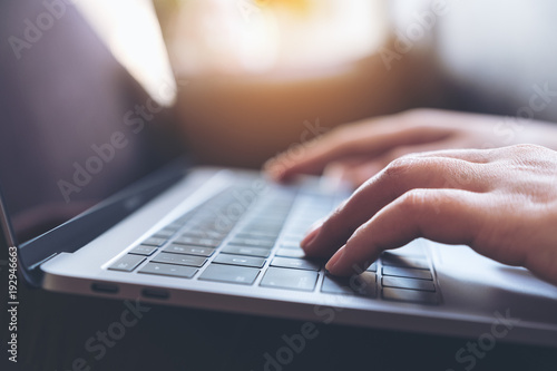 Closeup image of hands working and typing on laptop keyboard on the table photo
