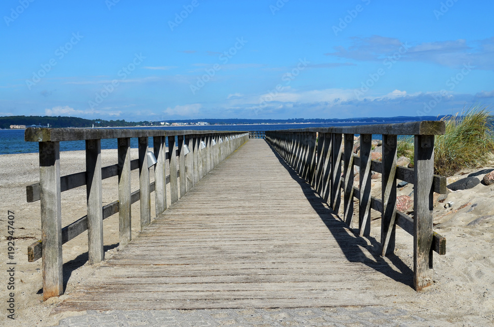 Wooden footbridge at beach with view to the Baltic Sea and the village Wooden footbridge at beach with view to the Baltic Sea and the village