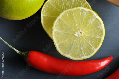 In the frame, slices of lime and hot red chili pepper. It is widely used in Asian and Mexican cuisine to give the dish a burning and slightly sour taste. Close-up. View from above. Macro photography.