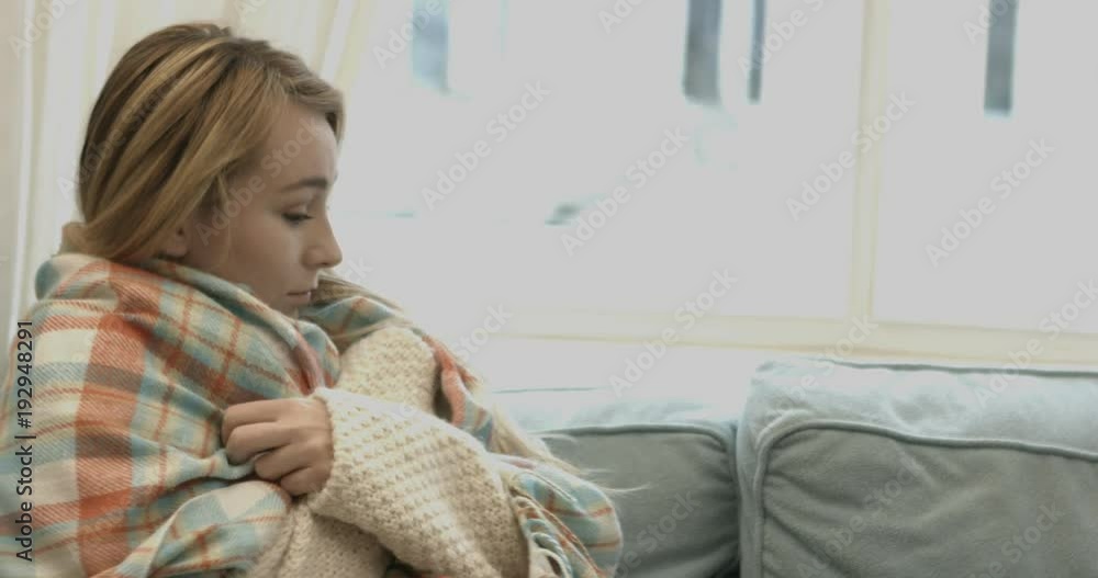 Sad and lonley woman sitting on sofa covering herself with blanket. Sad and lonley woman sitting on sofa covering herself with blanket.