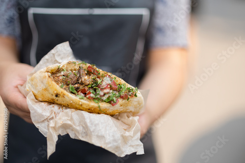 Obraz na plátně In the hands of the cook, falafel and fresh vegetables in pita bread