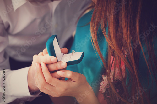 Canvas-taulu Young man makes a marriage proposal to his girlfriend and surprises her with a beautiful engagement ring