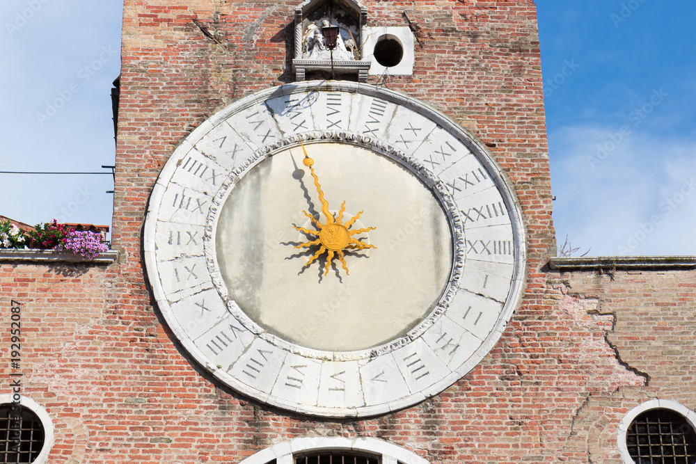 Old clock on the facade of a tenement house in Venice