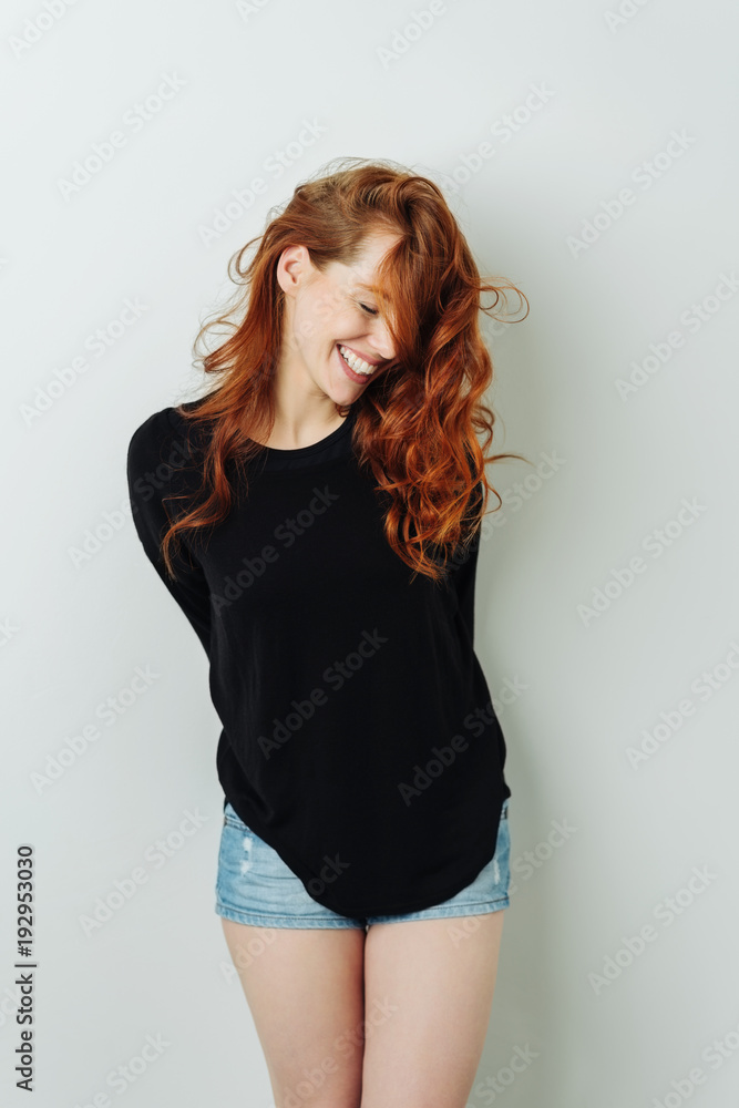 Fototapeta premium Seductive coy young redhead woman laughing