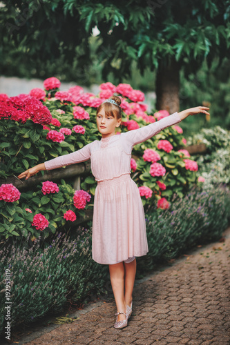 Little ballerina girl dancing in hydrangea garden, wearing tutu dress