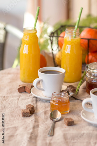 Breakfast with coffee cups, orange juice, makaron the outdoor terrace