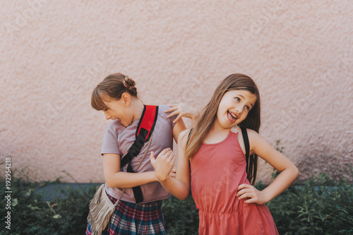 Bilde på lerret Two funny girls making grimace, silly schoolgirls playing together after school