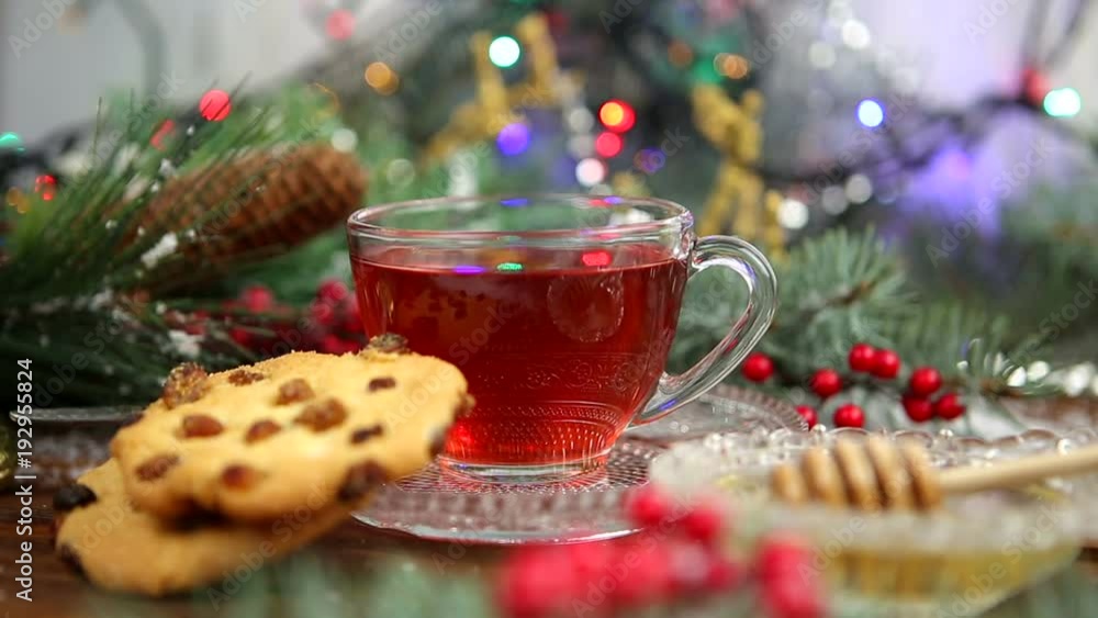 a cup of tea with honey and cookies, a branch of a Christmas tree in the snow, Christmas lights a cup of tea with honey and cookies, a branch of a Christmas tree in the snow, Christmas lights