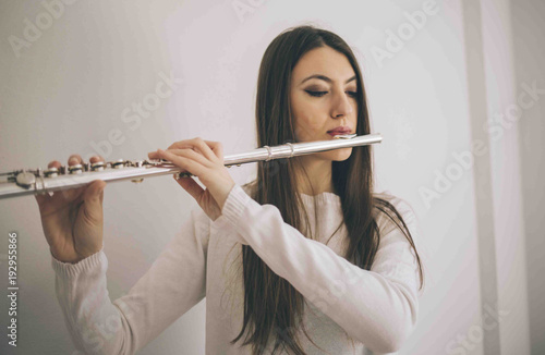 Young woman with flute. Female musician with her instrument performing.