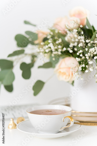 Blush wedding bouquet with roses and cup of tea. Portrait. Soft focus. Small depth