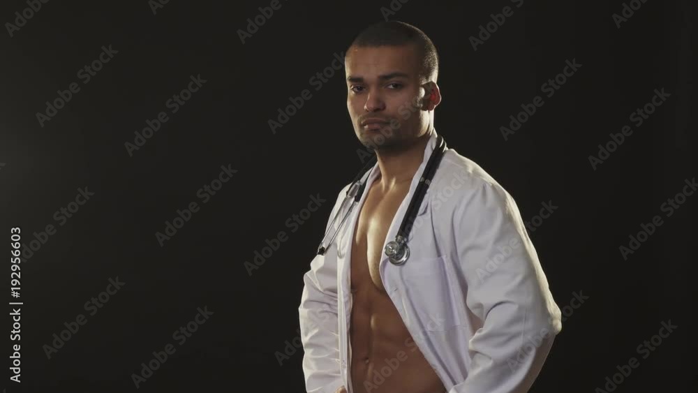 Handsome sexy male doctor with naked muscular torso winking to the camera Handsome sexy male doctor with naked muscular torso winking to the camera