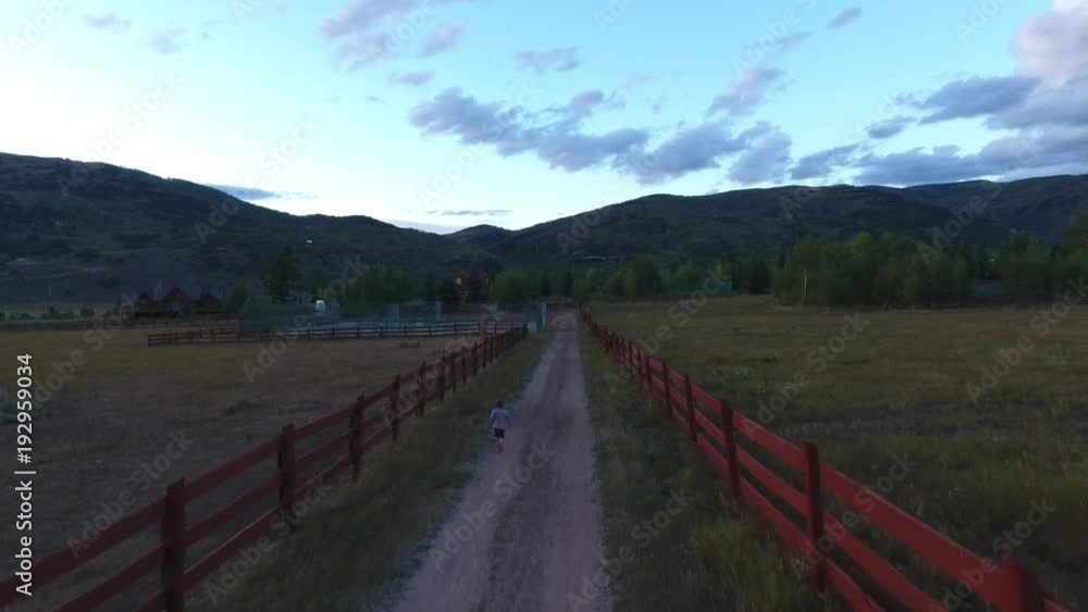 Boy running down a dirt road Boy running down a dirt road