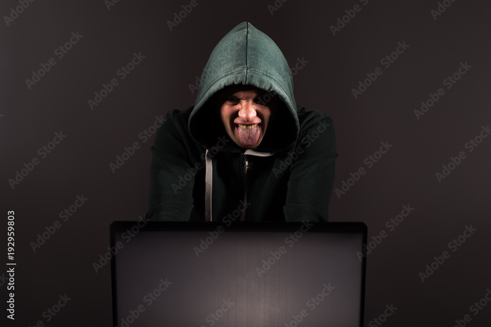 Hacker in front of his computer. Dark face Hacker in front of his computer. Dark face