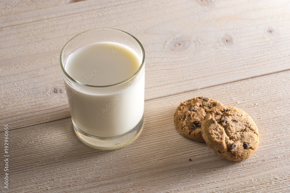 Glass of milk and cookies on a light wooden background Glass of milk and cookies on a light wooden background