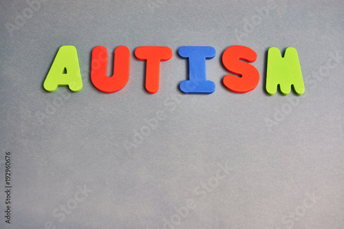Letters of the word autism on a Gray background with copy space.
