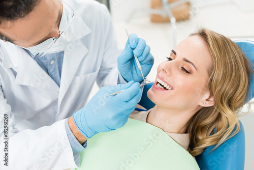 Doctor treats patient teeth in modern dental clinic