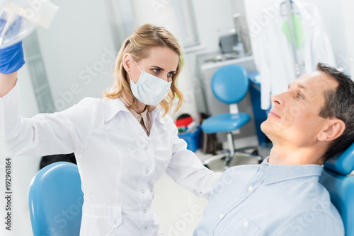 Doctor checking patient teeth in modern dental clinic