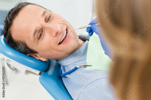 Dentist checking patient teeth in modern clinic