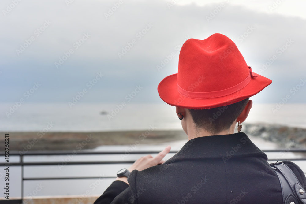 Donna  con il cappello rosso vista di schiena