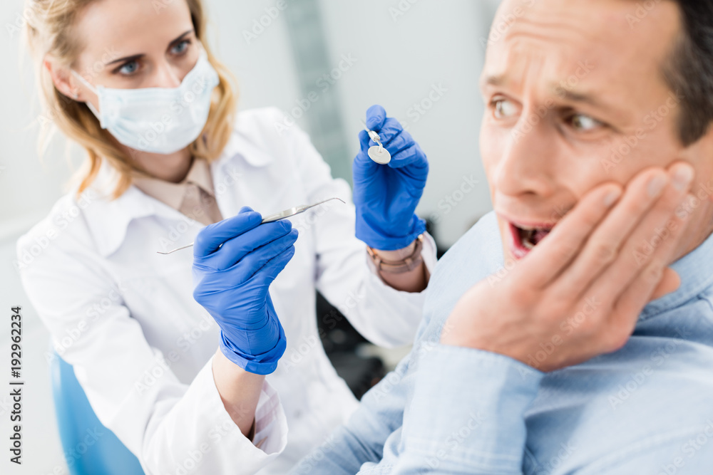 Male patient is afraid of dentist in modern dental clinic Male patient is afraid of dentist in modern dental clinic