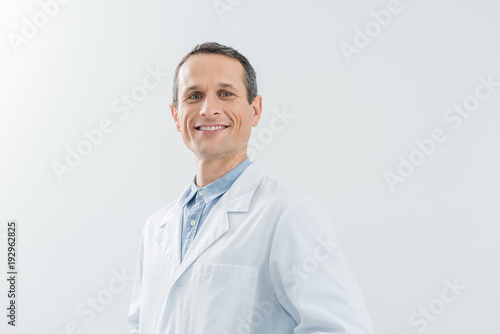 Smiling confident doctor by the wall in modern clinic © LIGHTFIELD STUDIOS