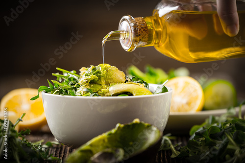 pouring olive oil to lettuce