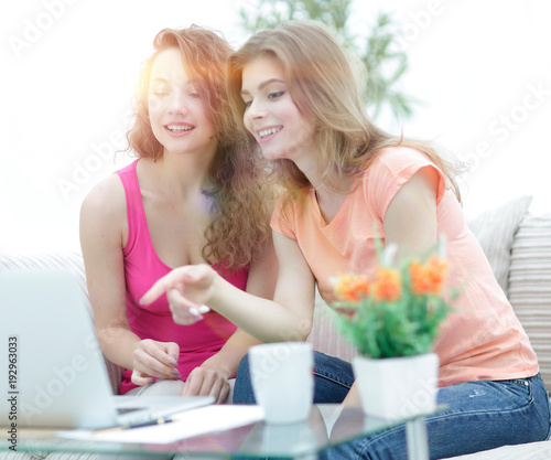 two young women talking and sitting down at the coffee table