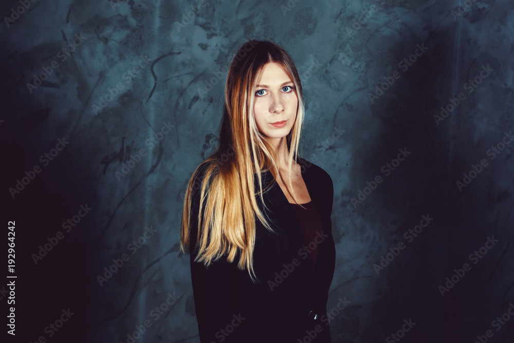 Attractive pretty young model posing against a dark studio background with copy space looking. Atomic blonde woman. Cold cinematic style Attractive pretty young model posing against a dark studio background with copy space looking. Atomic blonde woman. Cold cinematic style