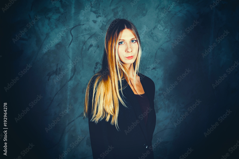 Attractive pretty young model posing against a dark studio background with copy space looking. Atomic blonde woman. Dramatic look Attractive pretty young model posing against a dark studio background with copy space looking. Atomic blonde woman. Dramatic look