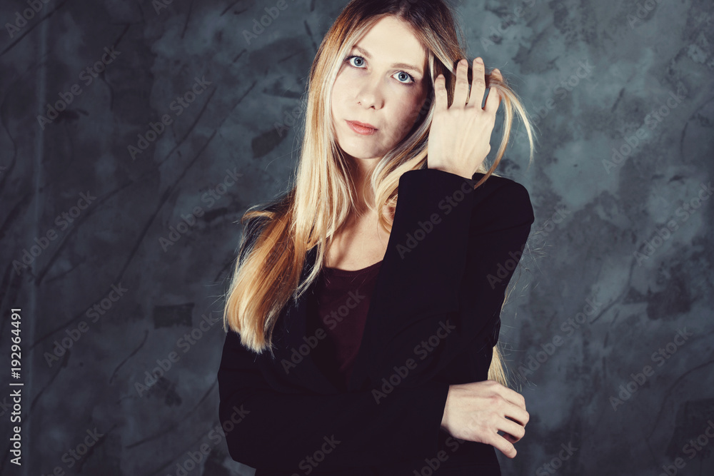 Attractive pretty young model posing against a dark studio background with copy space looking. Atomic blonde woman. Cold cinematic style Attractive pretty young model posing against a dark studio background with copy space looking. Atomic blonde woman. Cold cinematic style